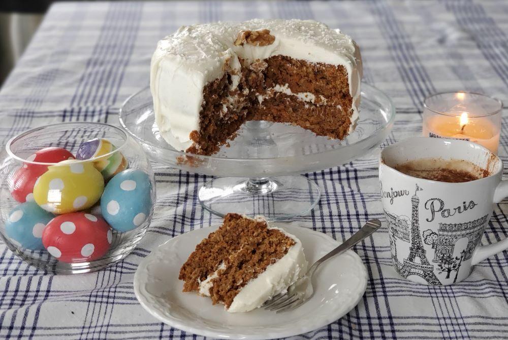 a photo of a carrot cake cut with a slice on a plate